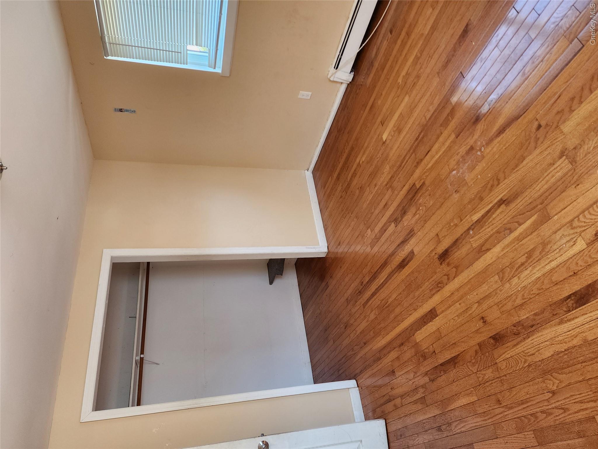 441 Morris Drive Valley Stream, NY 11580 - Photo 15 of 15 a view of an empty room with wooden floor and a window