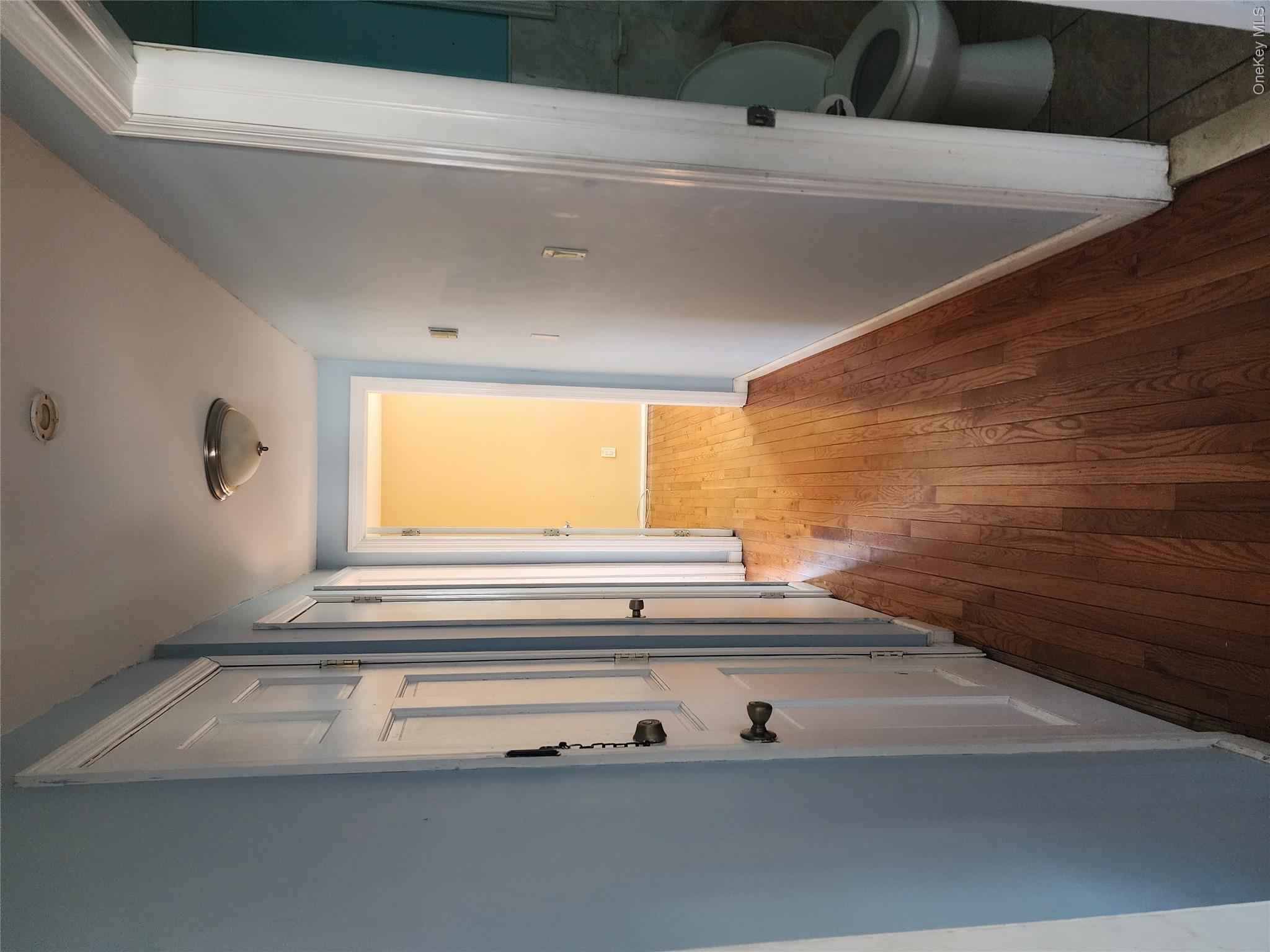 441 Morris Drive Valley Stream, NY 11580 - Photo 7 of 15 a view of a hallway with wooden floor and a bathroom