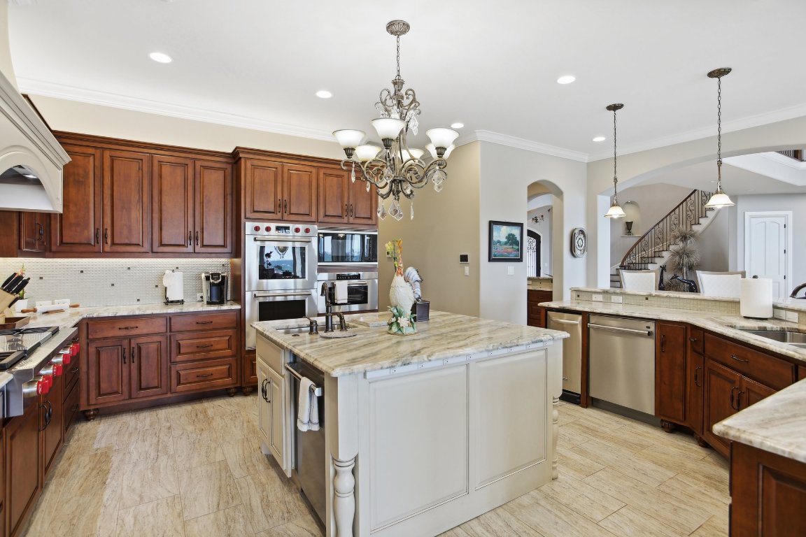 1353 Osprey Ridge Loop Lago Vista, TX 78645 - Photo 10 of 40 a kitchen that has a lot of white cabinets and stainless steel appliances