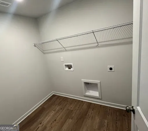 a view of a small space with wooden floor and fan