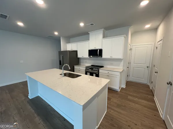 a kitchen with a sink a stove a refrigerator and a microwave