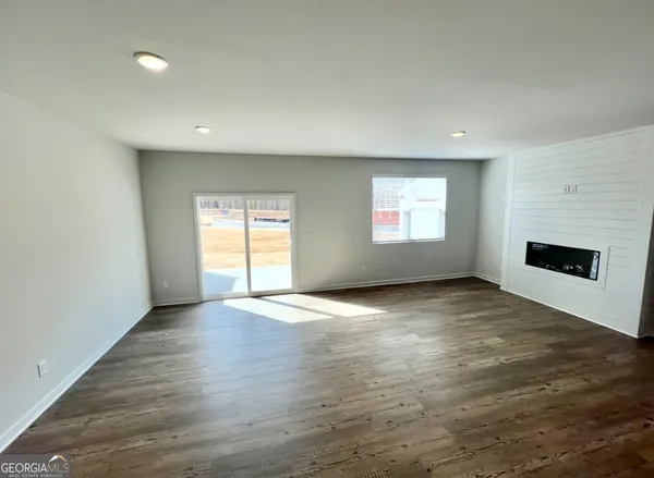 an empty room with windows and fireplace