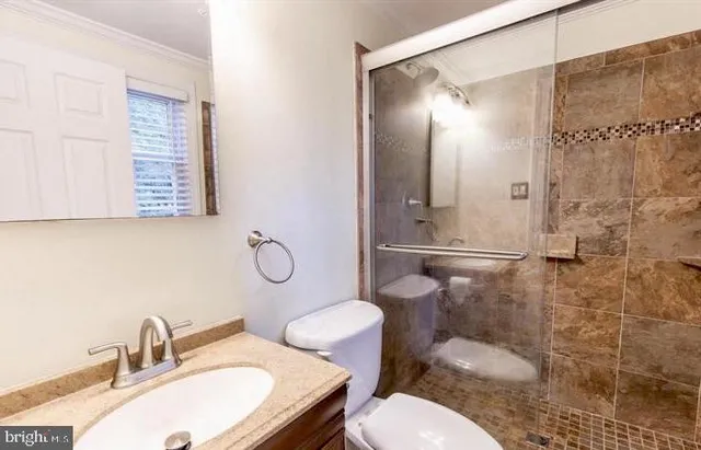 a bathroom with a sink toilet a mirror and shower