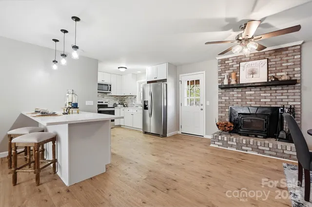 a open kitchen with cabinets a fireplace and a counter top space