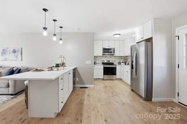 a kitchen with kitchen island a sink appliances and cabinets