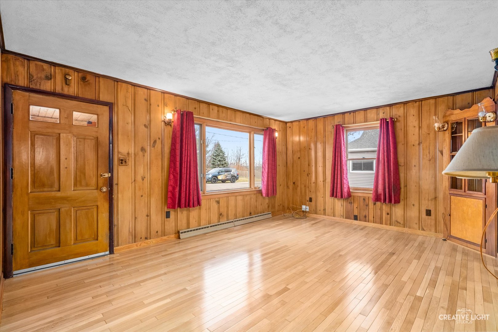 413 East Kansas Street Elburn, IL 60119 - Photo 5 of 18 a view of an empty room with wooden floor and windows