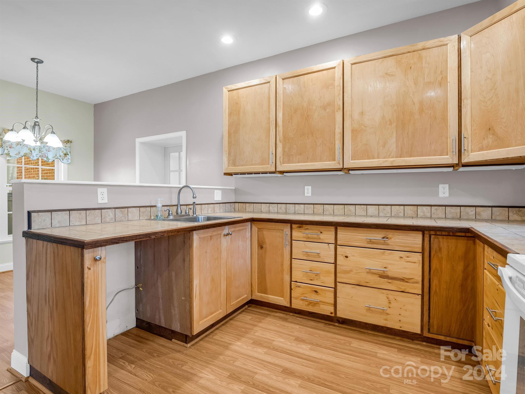 284 West T Wilkins Road Rutherfordton, NC 28139 - Photo 32 of 44 a kitchen with granite countertop wooden cabinets a sink and dishwasher
