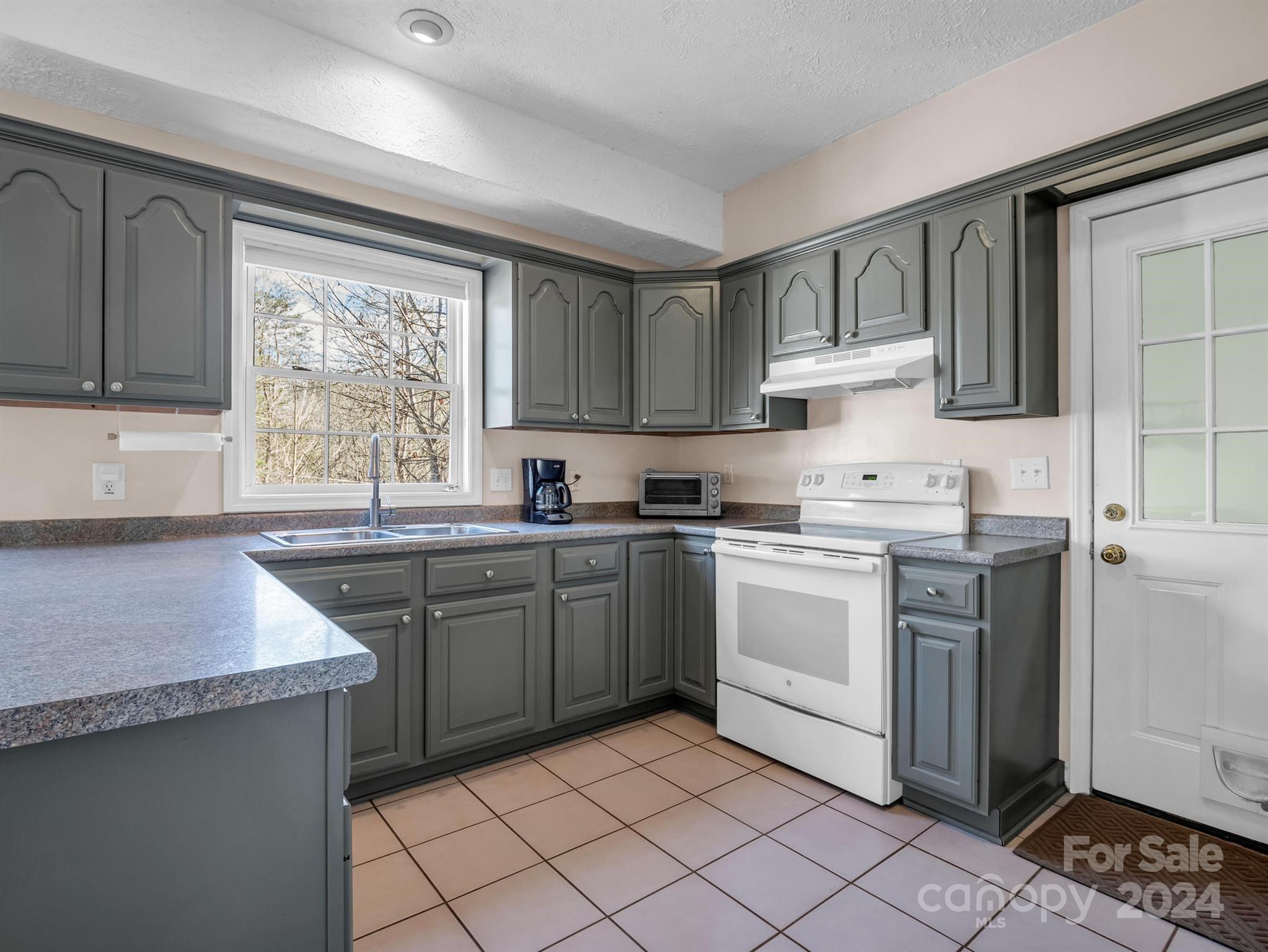 284 West T Wilkins Road Rutherfordton, NC 28139 - Photo 9 of 44 a kitchen with granite countertop cabinets stainless steel appliances a sink and a window