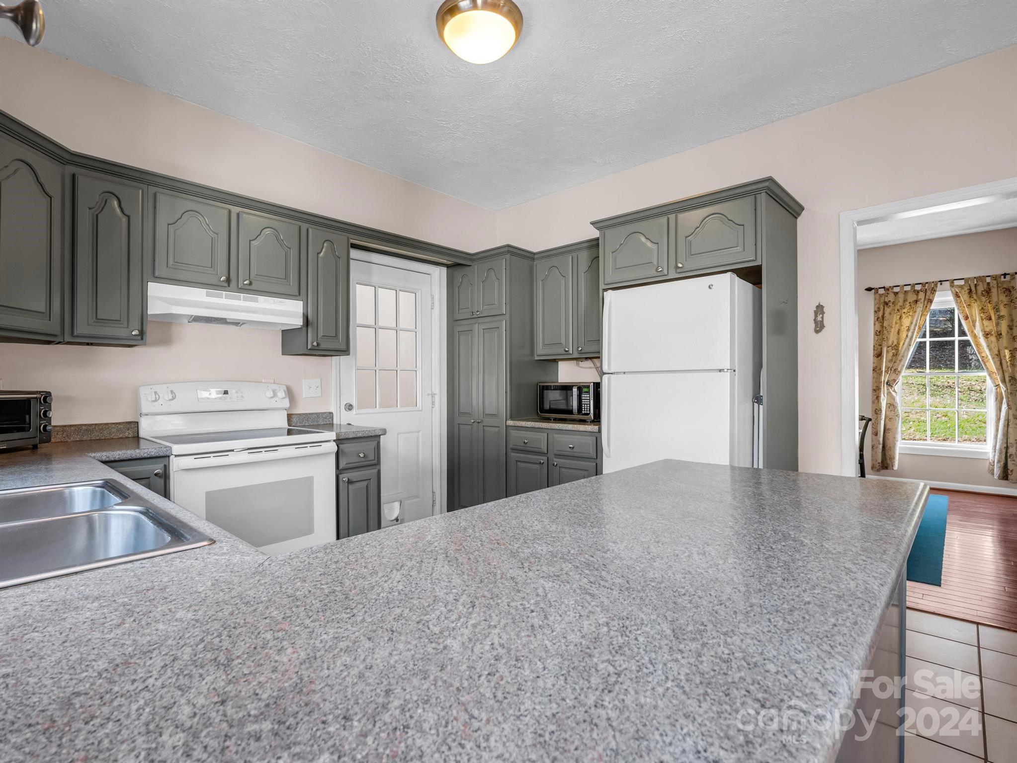 284 West T Wilkins Road Rutherfordton, NC 28139 - Photo 10 of 44 a kitchen with refrigerator cabinets and a sink
