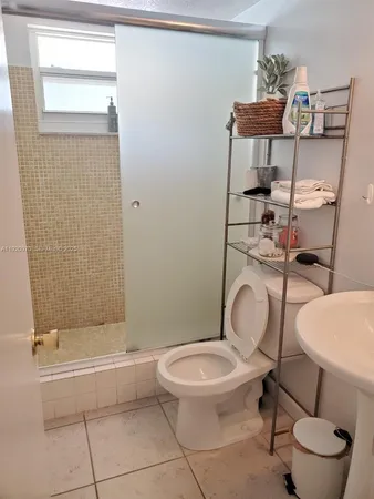 a white toilet sitting next to a bathroom sink and tub