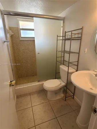 a bathroom with a toilet a sink and shower
