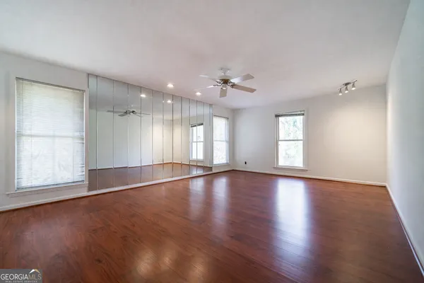an empty room with wooden floor and windows