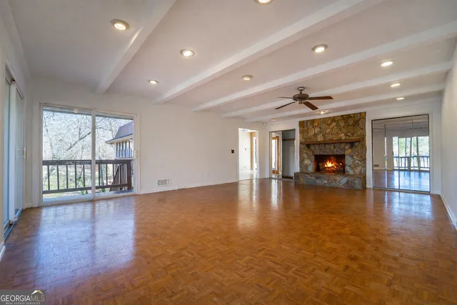 an empty room with wooden floor and a fireplace