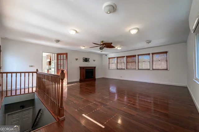 an empty room with wooden floor and fireplace