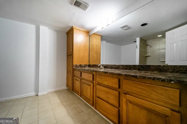 a bathroom with a granite countertop sink and a mirror