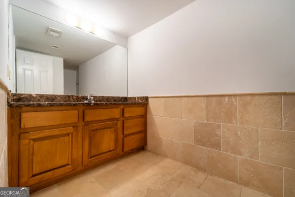 a bathroom with a granite countertop sink and a mirror