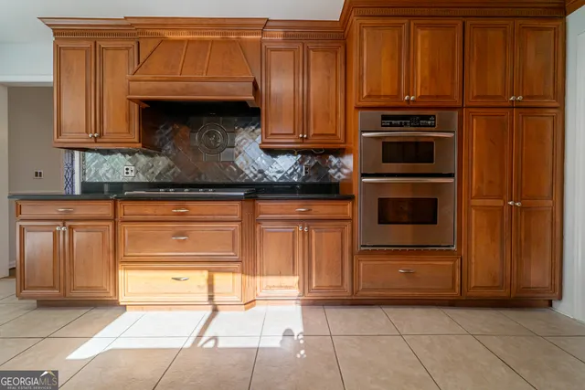 a kitchen with granite countertop wooden cabinets and a stove top oven