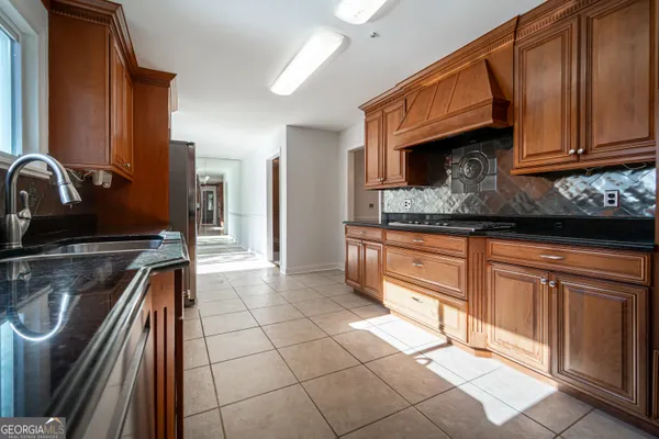 a kitchen with granite countertop a stove a sink and a microwave