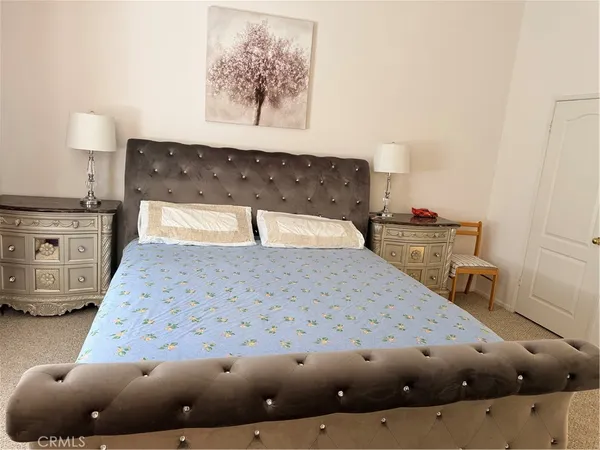 a bedroom with a bed and a painting on the wall