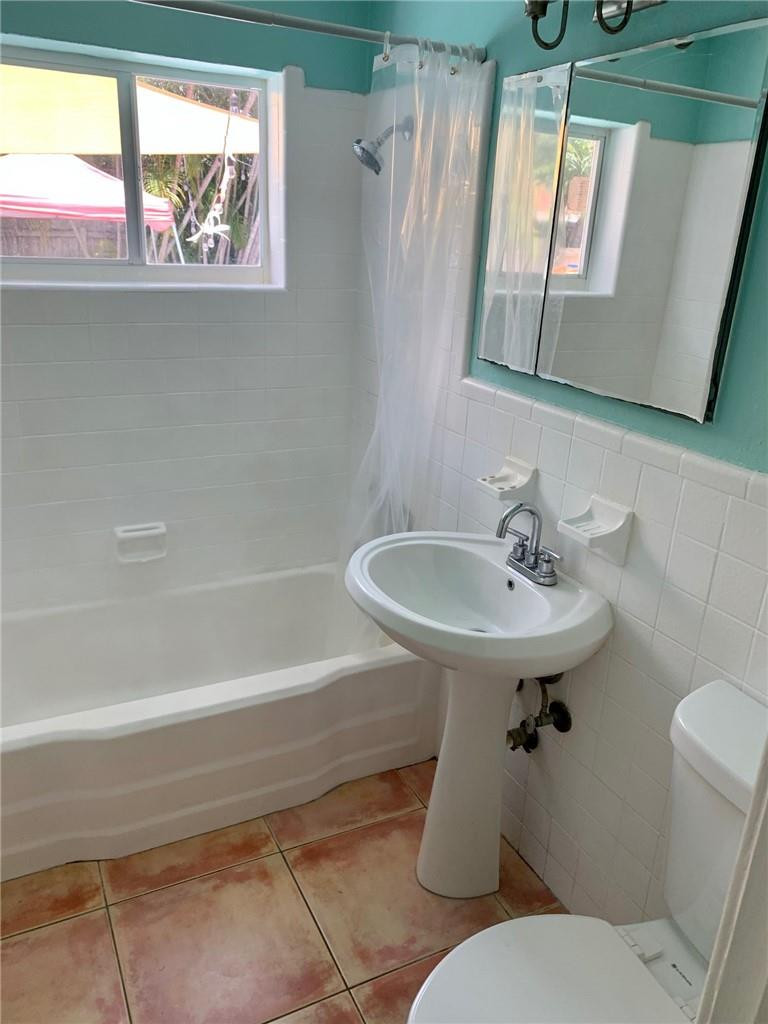 1101 Southwest 1st Avenue Pompano Beach, FL 33060 - Photo 22 of 30 a white toilet sitting next to a bathroom sink