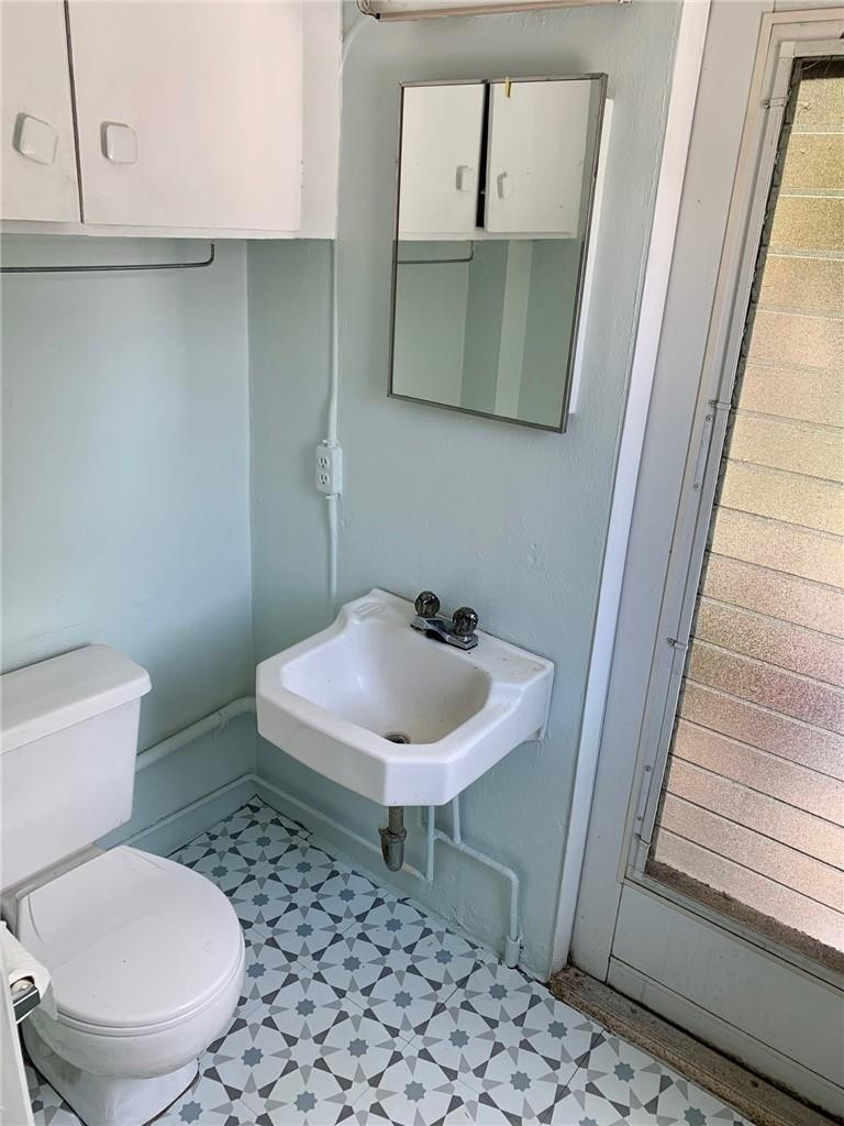 1101 Southwest 1st Avenue Pompano Beach, FL 33060 - Photo 27 of 30 a bathroom with a toilet a sink and mirror