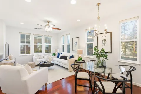 a living room with furniture kitchen view and a flat screen tv