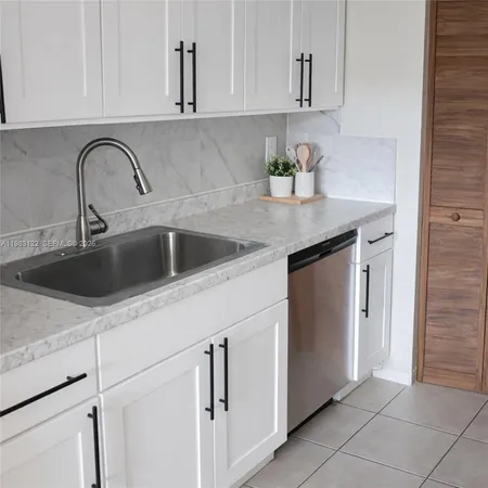 a close view of a kitchen sink and cabinets