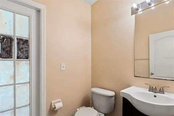 a bathroom with a toilet a sink and mirror