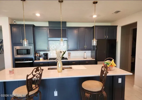 a kitchen with stainless steel appliances granite countertop a sink refrigerator and microwave
