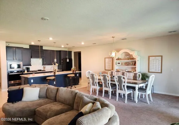 a living room with furniture kitchen view and a dining table