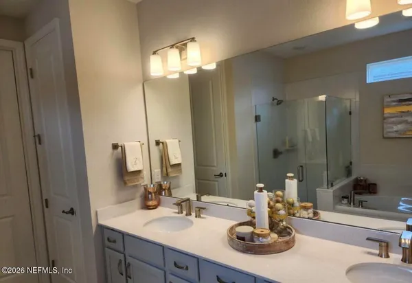 a bathroom with double vanity sinks and a mirror