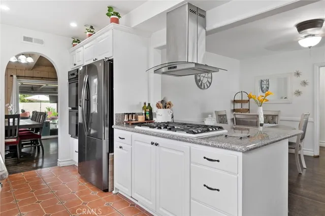 a kitchen with stainless steel appliances granite countertop a stove a sink and a refrigerator
