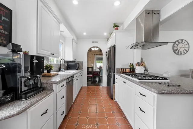 a large kitchen with stainless steel appliances lots of counter space and wooden floor