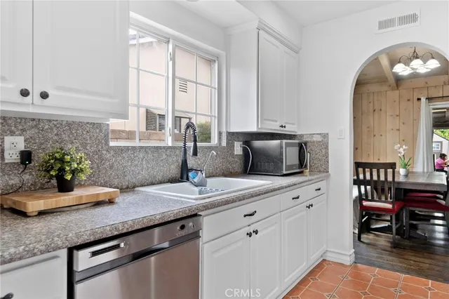 a kitchen with granite countertop a sink white cabinets and a granite counter tops