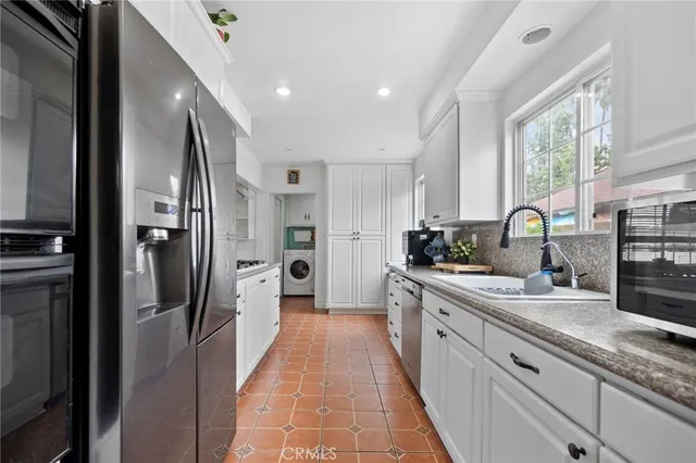 a kitchen with stainless steel appliances granite countertop a refrigerator and a sink