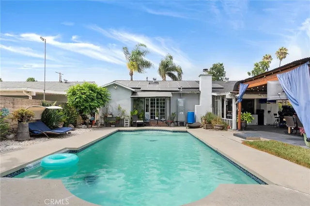 a view of a house with swimming pool and sitting area