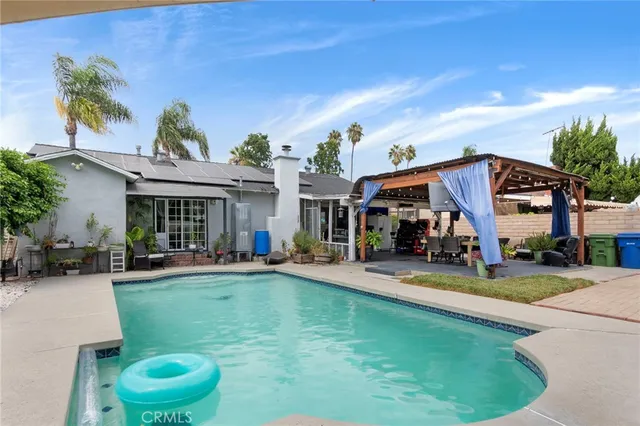 a view of a house with swimming pool and sitting area