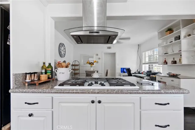 a kitchen with kitchen island granite countertop stainless steel appliances a sink and stove