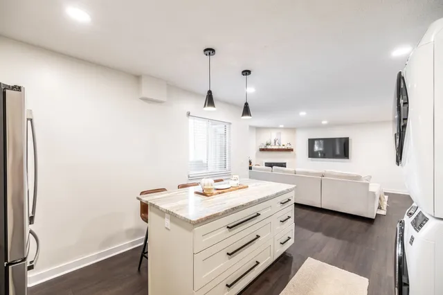 a kitchen view with stainless steel appliances kitchen island hardwood floor and a window