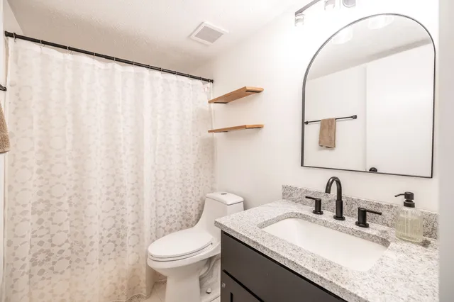 a bathroom with a granite countertop sink and a mirror