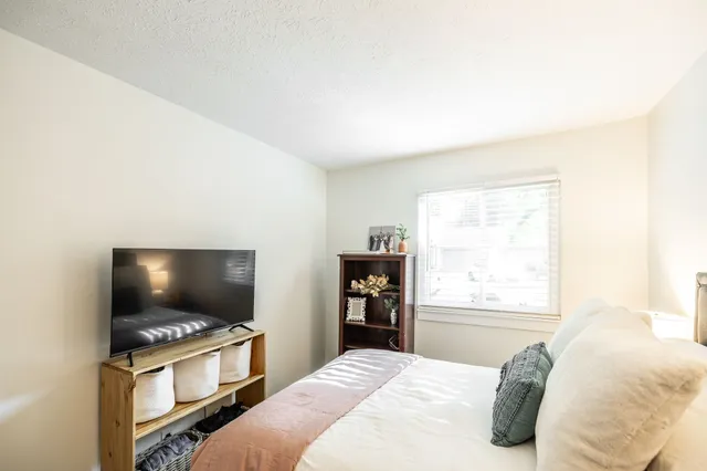 a bedroom with a bed and a flat screen tv