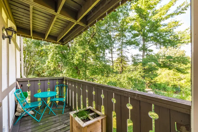 a view of deck with furniture and trees