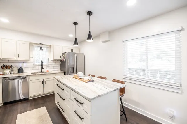 a kitchen that has a microwave a sink and a stove in it