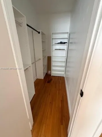 a view of walk in closet with wooden floor