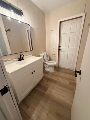 a bathroom with a sink and mirror with toilet
