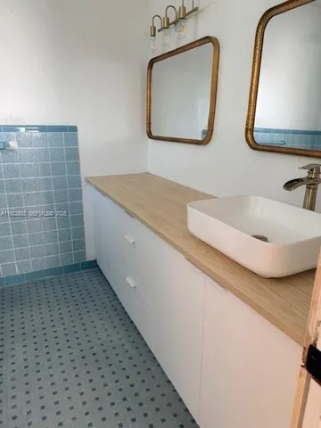 a bathroom with a double vanity sink and mirror