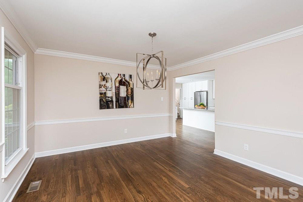 1701 Pony Run Road Raleigh, NC 27615 - Photo 5 of 30 Separate Dining Room with hardwood floors, crown molding, and chair railing opens to large kitchen