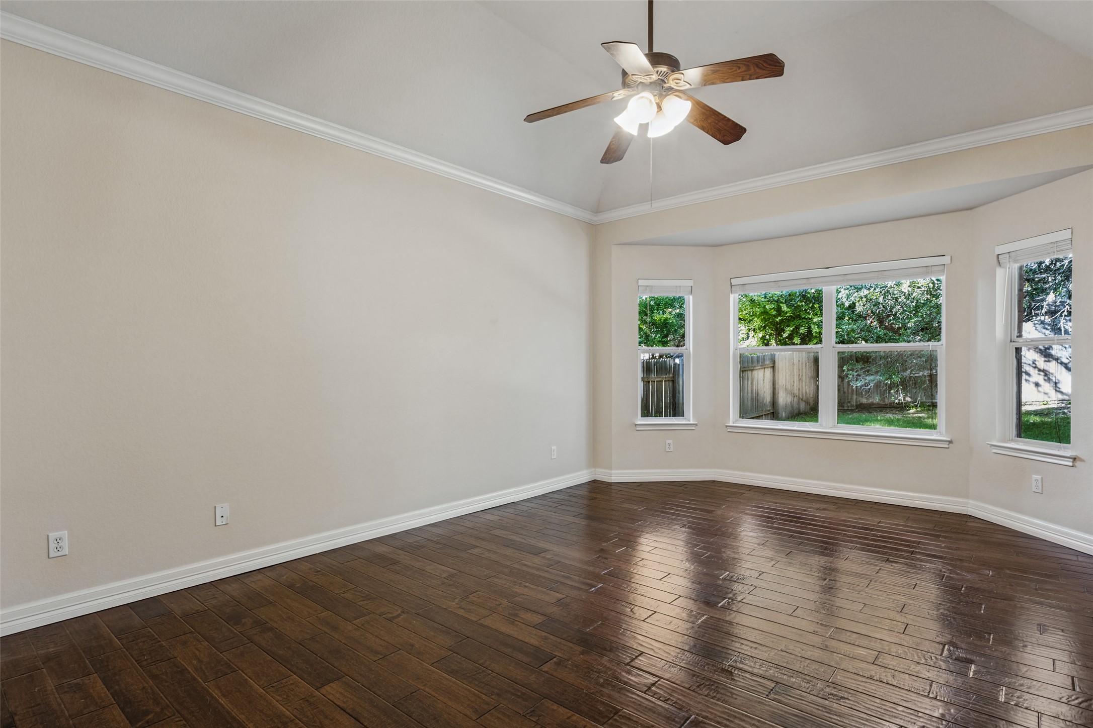 2832 Grimes Ranch Road Austin, TX 78732 - Photo 12 of 23 Rich hardwood flooring and a vaulted ceiling elevate this airy, light-filled bedroom space.