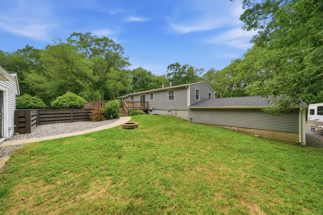 214 Anan Wade Road Glocester, RI 02857 - Photo 40 of 50 Gather around the stone-surround firepit in this spacious side yard—perfect for cool evenings, conversation and s’mores under the trees.