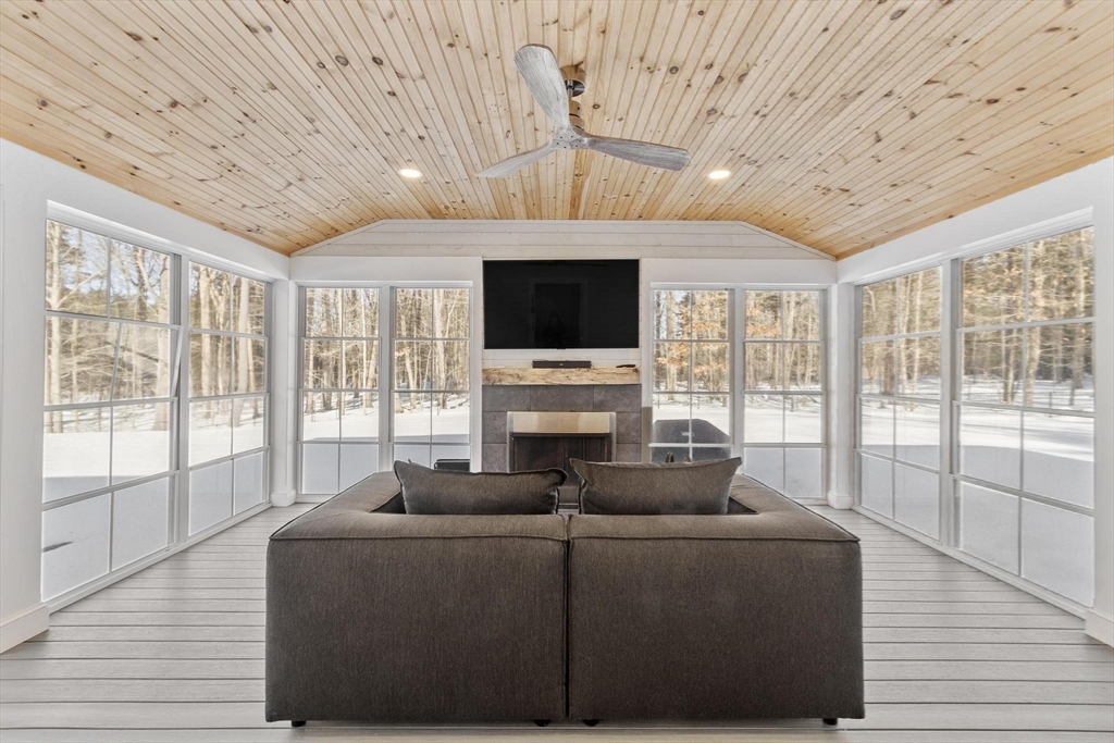 3 Swett Drive Hampton, NH 03842 - Photo 16 of 42 a living room with furniture a flat screen tv and a floor to ceiling window